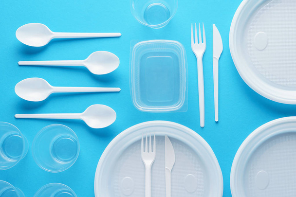 Various white plastic disposable tableware on blue background. - Foto, Bild