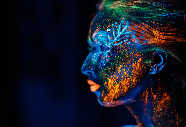 Portrait of a girl painted in fluorescent powder - Photo, Image