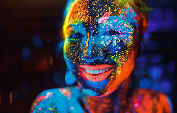 Portrait of a girl painted in fluorescent powder - Фото, изображение