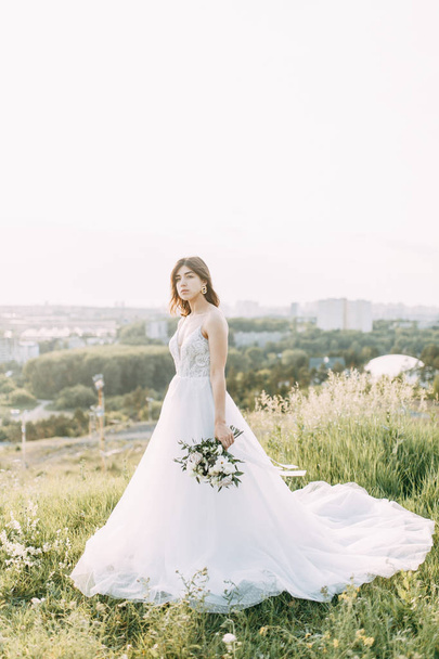 Bride with long dress in nature with sunset. A stylish wedding in the European style of fine art.  - Φωτογραφία, εικόνα