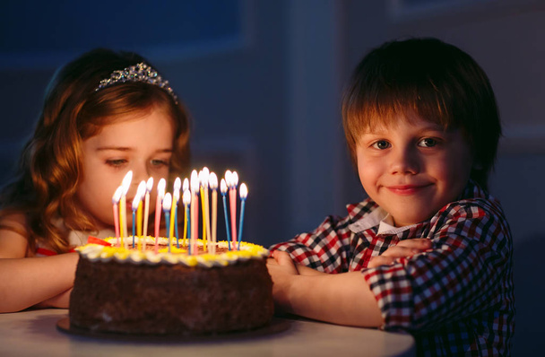 Childrens birthday. Children near a birthday cake with candles. - Fotoğraf, Görsel
