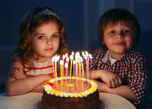 Childrens birthday. Children near a birthday cake with candles. - Foto, Imagen
