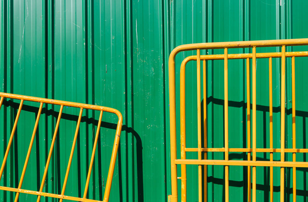 zöld színű fém fal és sárga gáton háttér - Fotó, kép