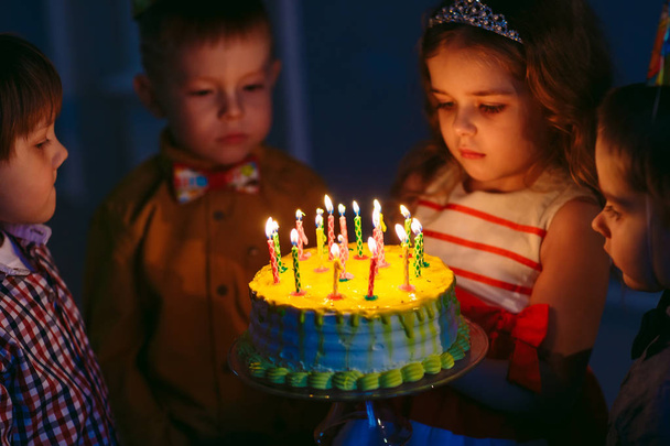 Childrens birthday. Children near a birthday cake with candles - Zdjęcie, obraz