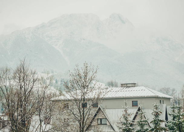 Foggy Tatra-gebergte in de winter met gebouw aan de voorkant. - Foto, afbeelding