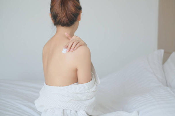 Frau Anwendung ihrer Rückencreme, Lotion, Hygiene Haut Körperpflege co - Foto, Bild