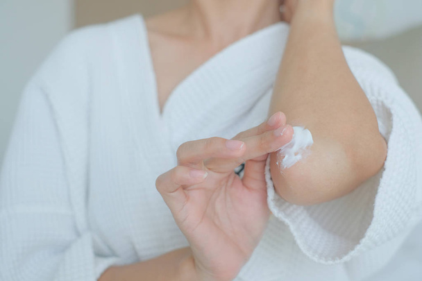 Γυναίκα που εφαρμόζει κρέμα αγκώνα, λοσιόν, υγιεινή περιποίηση σώματος δέρματος - Φωτογραφία, εικόνα