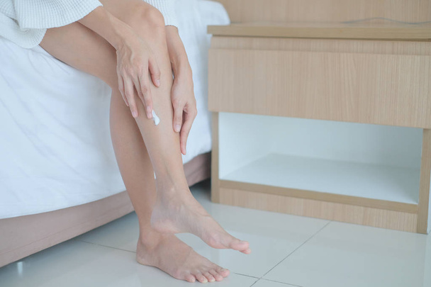 Femme appliquant jambes crème, lotion, Hygiène peau soin du corps concéder
 - Photo, image