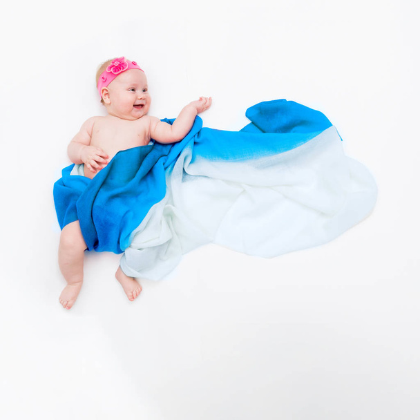 top view of cute infant baby wrapped in a light blue scarf like angel on the cloud - Photo, Image