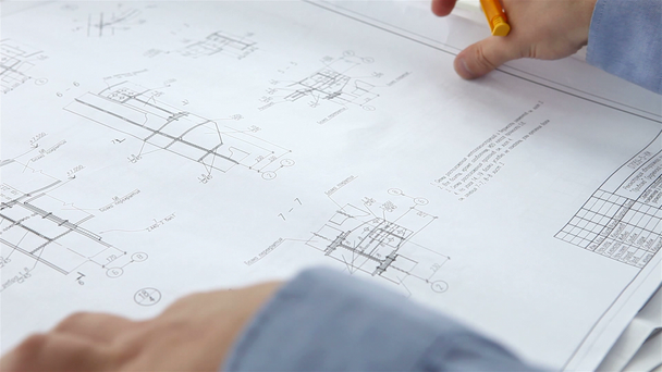 Mérnök ellenőrzi az építőipari rajzok - Felvétel, videó