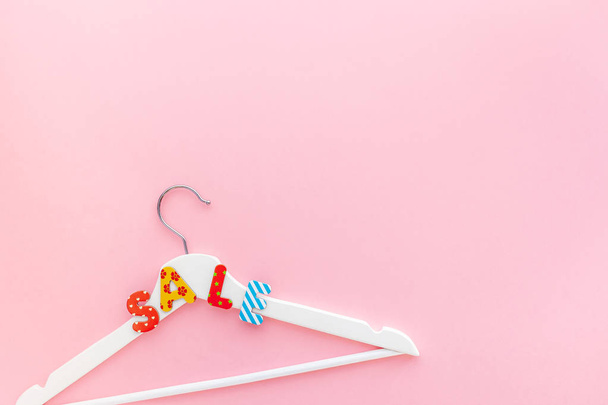 White hangers with sale text on pink background - 写真・画像