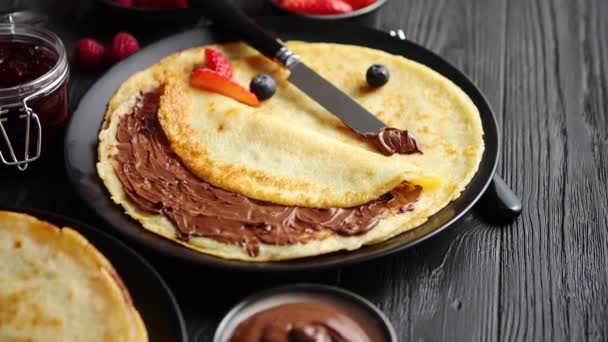 A fekete kerámia tányér finom csokoládé házi palacsinta - Felvétel, videó