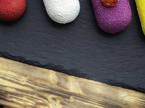 Выбор красочных десертных пирожных сладкие мини-торты на шифер и деревянный фон
 - Фото, изображение