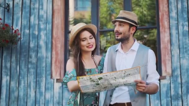 δύο τουρίστες εξερευνούν τον χάρτη στα ταξίδια. μια νεαρή γυναίκα και ένας άντρας περπατάει στην πόλη σε ένα ταξίδι - Πλάνα, βίντεο