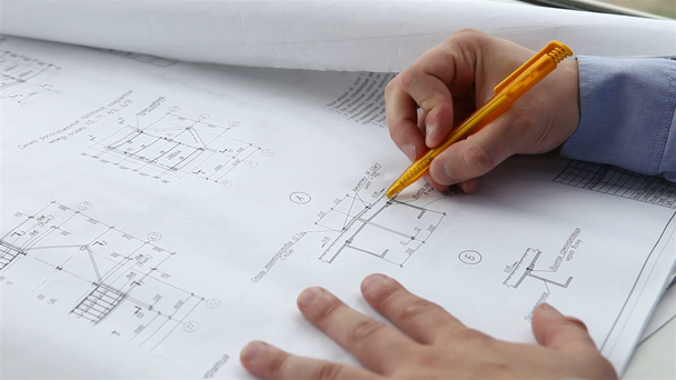 Mérnök ellenőrzi az építőipari rajzok - Felvétel, videó
