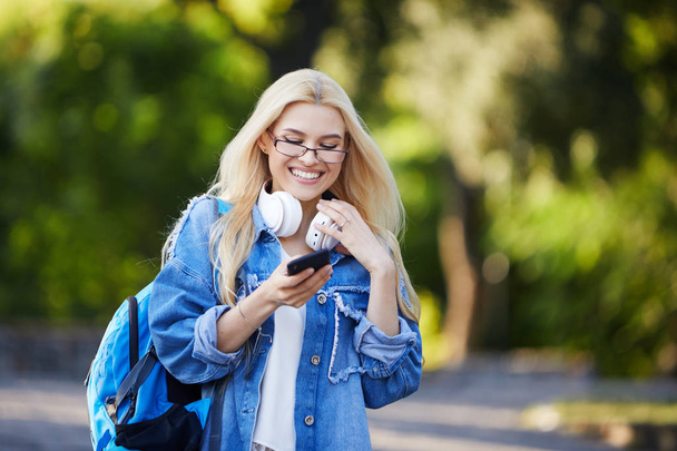 Front view of young excited female student receiving good news on line in a mobile phone in an university campus or street. Concept of winner - Foto, Bild