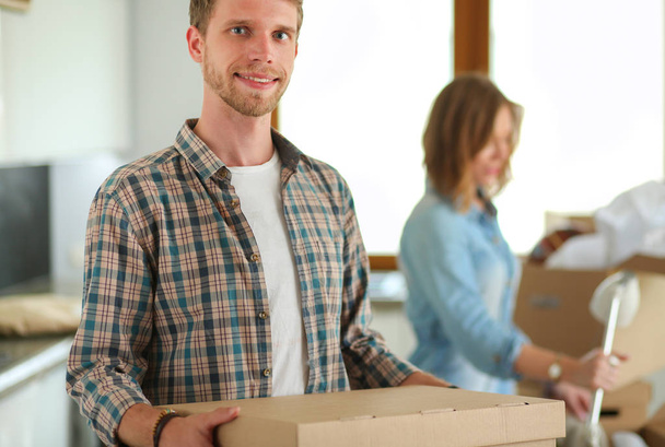Couple unpacking cardboard boxes in their new home. Young couple. - Foto, Bild