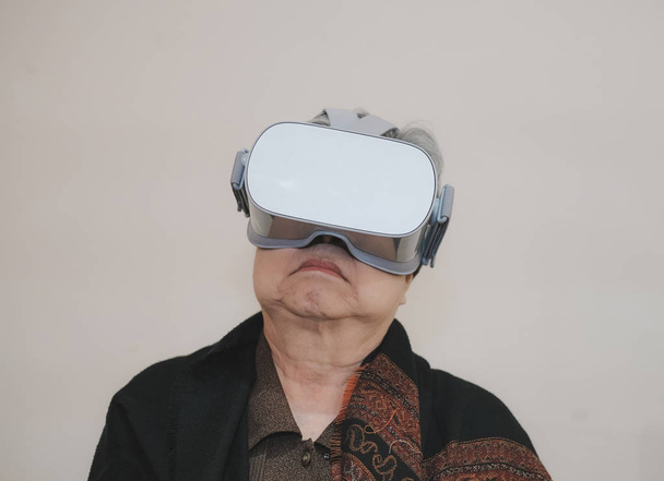 old senior woman wearing virtual reality goggles. VR headset dev - Photo, Image