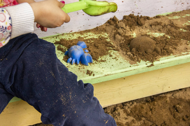 Children play in a sandbox with molds and knives. Sculpting sand figures. - Valokuva, kuva