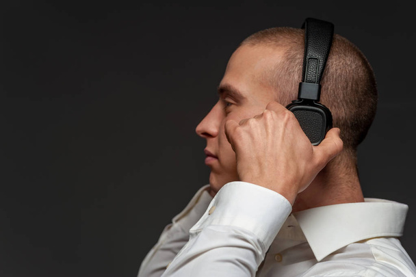 Young DJ guy listening to music in headphones - Fotografie, Obrázek