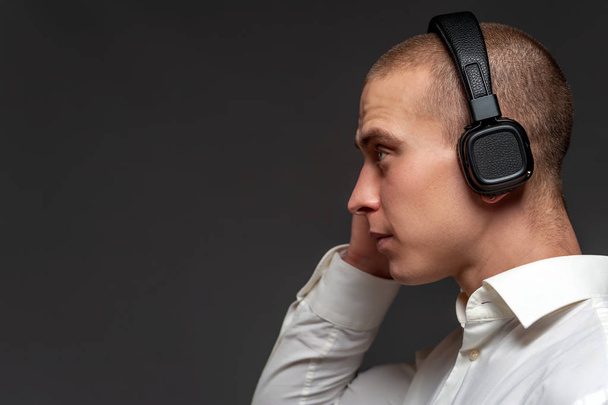 Young DJ guy listening to music in headphones - Foto, Bild