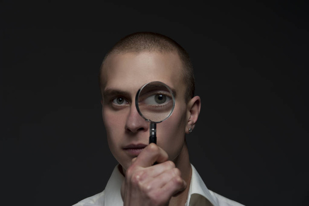 Guy looking through a magnifying glass - Foto, afbeelding