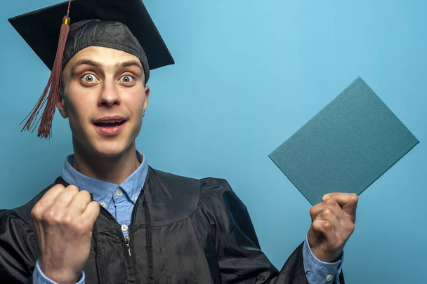 Happy Graduate man holding up a diploma - Foto, imagen