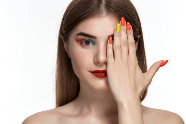 Closeup portrait of beautiful young woman with bright color make-up holding hands with bright  manicure close to face - Foto, Imagem