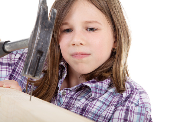 Young girl with hammer and nail - Foto, afbeelding