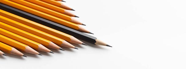 Group of yellow classic pencils following black one - Photo, Image