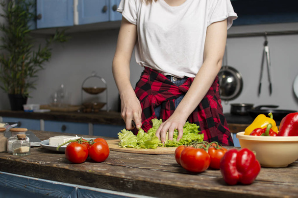 ruce dívky nakrájejí salát na stole, Žena připravuje vegetariánské saláty, zdravé jídlo, zelené nože - Fotografie, Obrázek