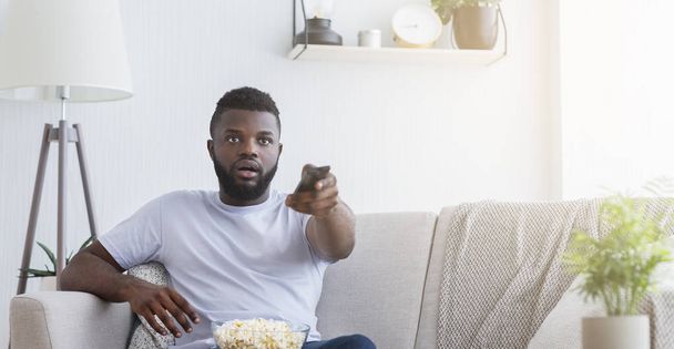 Homme afro-américain regardant la télévision à la maison, espace de copie
 - Photo, image