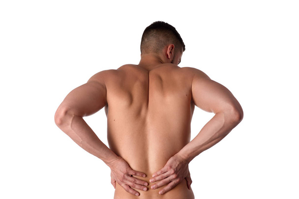Young man with back pain. The athlete clings to a sore back. Man hurt his back. Sports medicine concept - Photo, Image