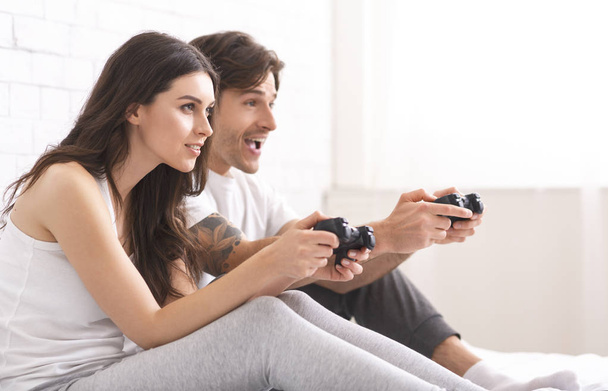 Концентрированные мужчина и женщина соревнуются в видеоиграх
 - Фото, изображение