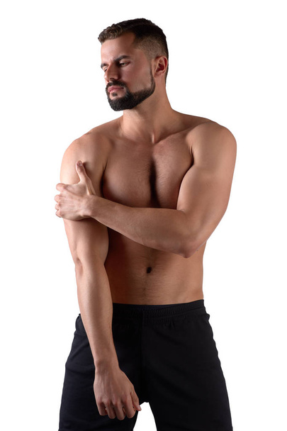 Svalnatý silný muž s bolestí na rameni, izolovaný na bílém pozadí - Fotografie, Obrázek