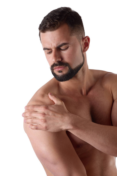 Hombre musculoso fuerte con dolor de hombro, aislado sobre fondo blanco. Deportista sostiene su hombro dolorido
 - Foto, imagen