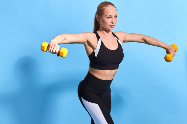 Beautiful young blonde woman with stretched arms doing exercises - Foto, immagini