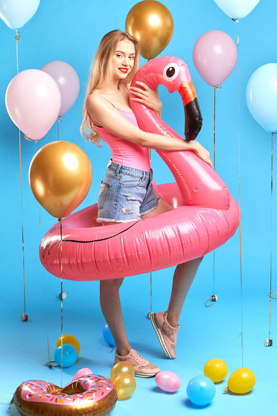 good looking fair-haired girl in pink top, denim jeans, trainers - 写真・画像