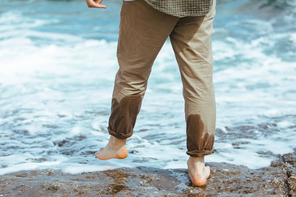 bagnato uomo gambe in pantaloni a piedi dal mare spiaggia rocciosa godendo di acqua
 - Foto, immagini
