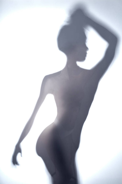 blurred image of young woman with raised arm looking aside - Photo, Image