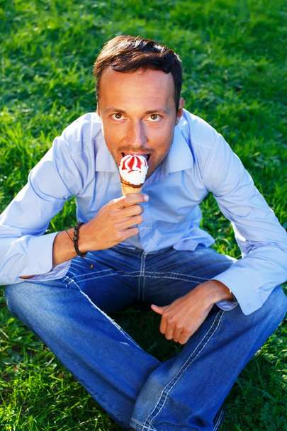 Happy handsome middle-aged man eating ice- cream outdoors - Photo, Image