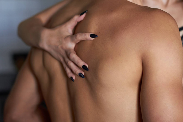 womans hands on mans back. close up photo - Foto, imagen