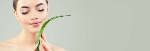Beautiful woman with healthy skin and aloe vera leaf in her hand - Фото, зображення