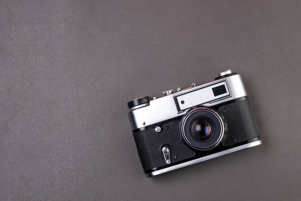 oude film camera zilver kleur op zwarte achtergrond papier - Foto, afbeelding