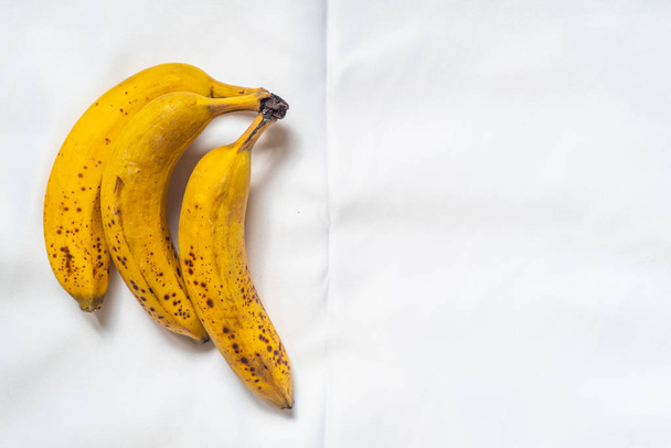 drie bananen op witte achtergrond - Foto, afbeelding