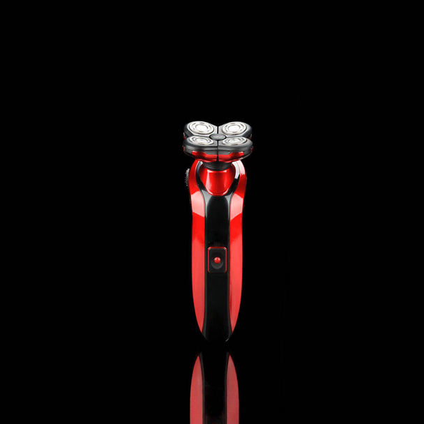 Электрическая красная бритва, стрижка изолирована на черном зеркале сзади
 - Фото, изображение