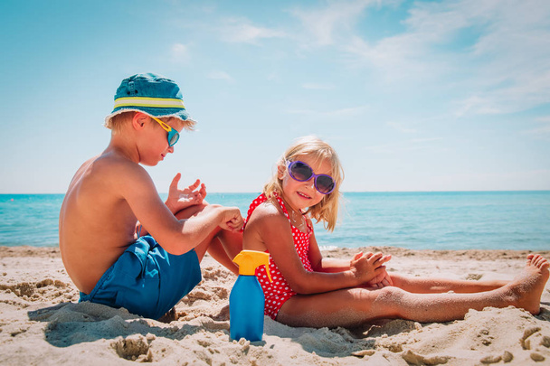 Sluneční ochrana, roztomilá dívka a chlapec se zmrzlinou na pláži - Fotografie, Obrázek