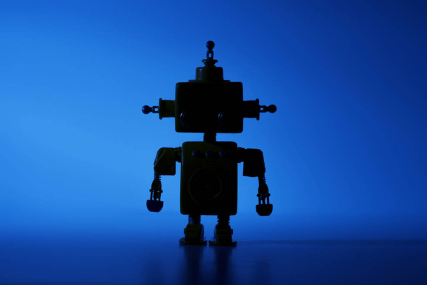 Silhouet van een leuke robot op een blauwe achtergrond. - Foto, afbeelding