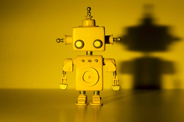 Robot on a yellow background. - 写真・画像