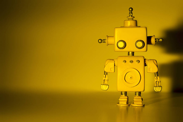 Robot on a yellow background. - Foto, Imagen